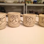 A row of four mugs with Googly eyes