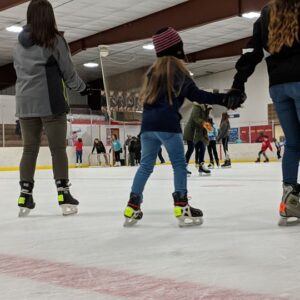 young people ice skating in a skating rink