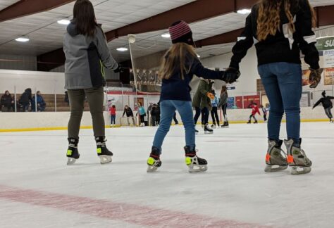 young people ice skating in a skating rink