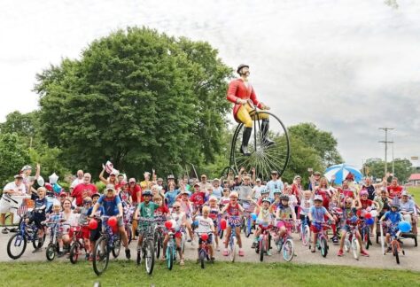 A large group of bicyclists wearing red white and blue.