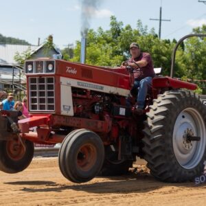 A red tractor with its front wheels off the ground