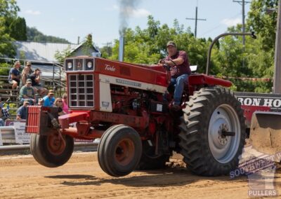 A red tractor with its front wheels off the ground
