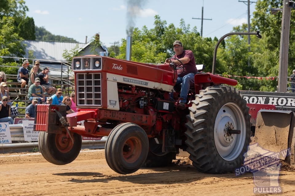 A red tractor with its front wheels off the ground