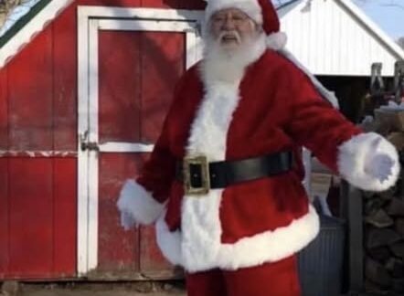 Santa Claus outside a red shed