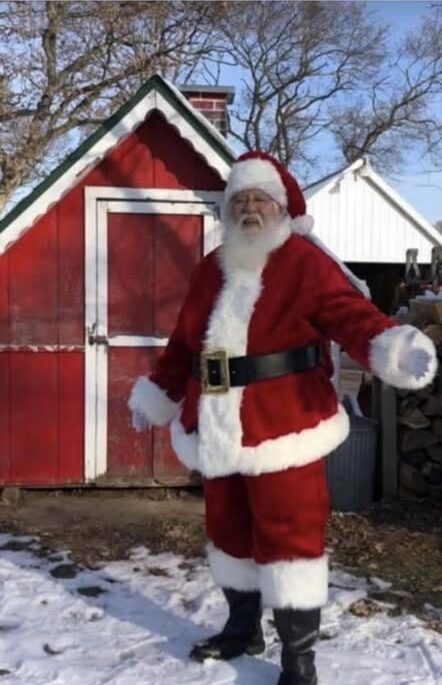 Santa Claus outside a red shed