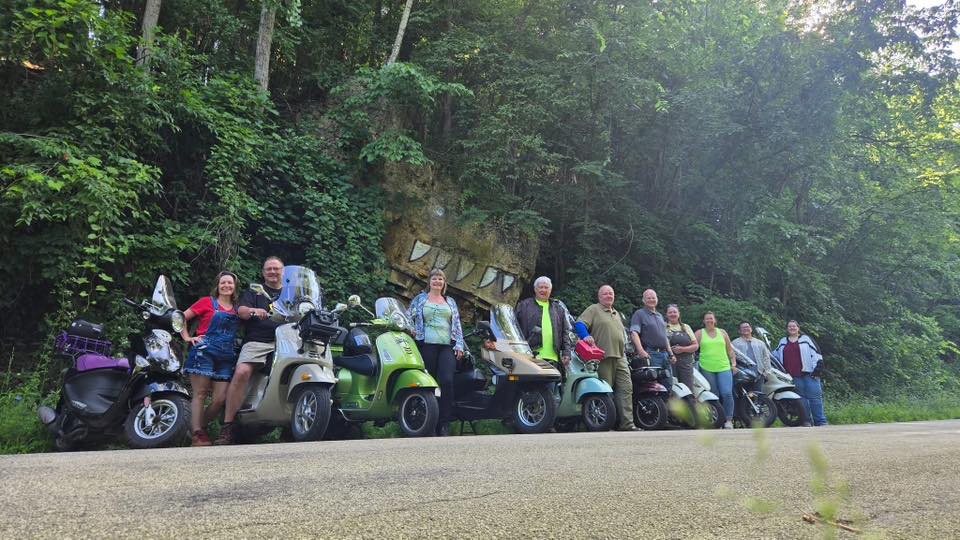 A line of scooters along a road in the driftless