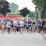 A large group of runners coming down a street