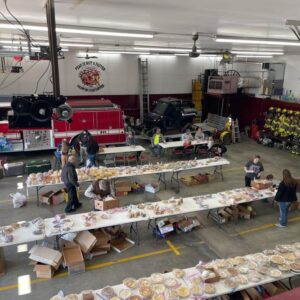 A overview picture of Cashton Fire and Responders holding boxes and setting tables.