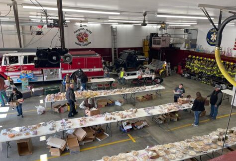 A overview picture of Cashton Fire and Responders holding boxes and setting tables.