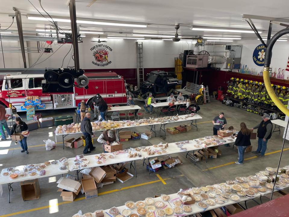 A overview picture of Cashton Fire and Responders holding boxes and setting tables.