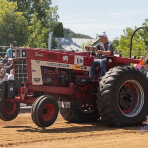 A picture of a man riding a tractor.