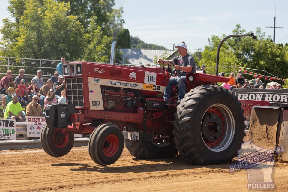 A picture of a man riding a tractor.