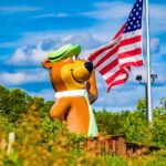A statue of Yogi Bear saluting beside a waving American flag