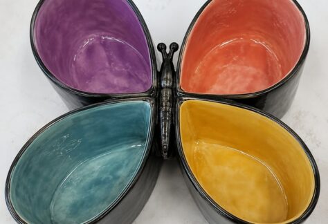 A multi colored serving dish shaped like a butterfly