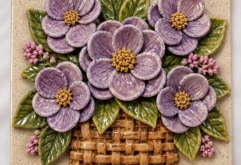 A ceramic tile with a floral basket motif