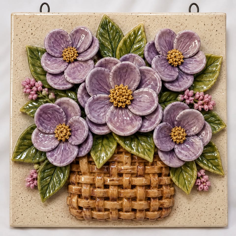 A ceramic tile with a floral basket motif
