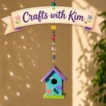 A small painted bird house hanging from a string of beads