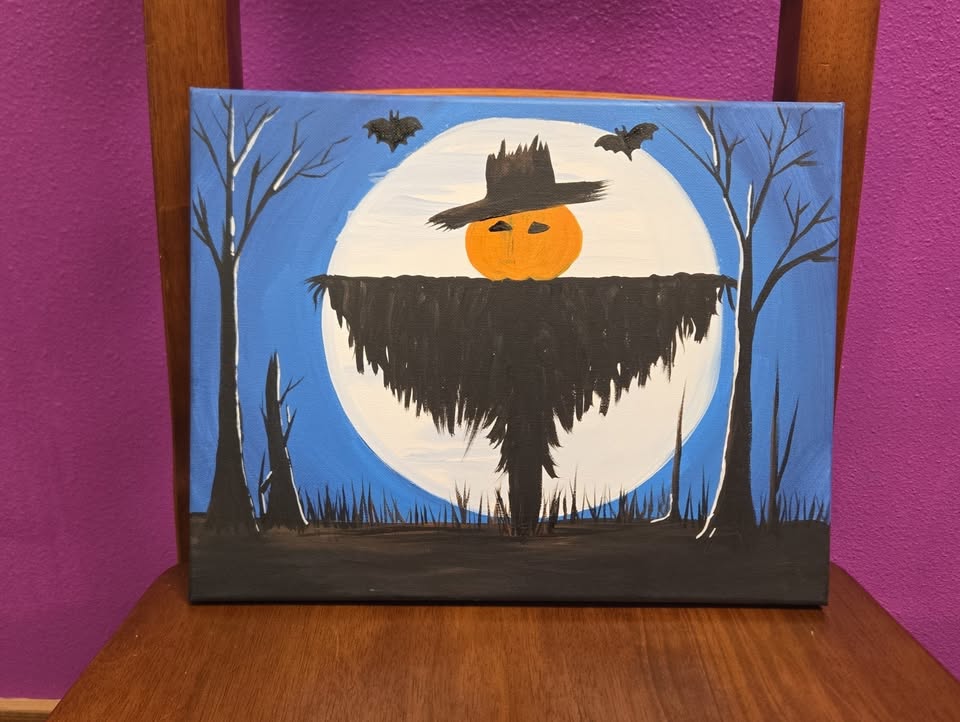 A canvas painting of a scarecrow in front of the full moon